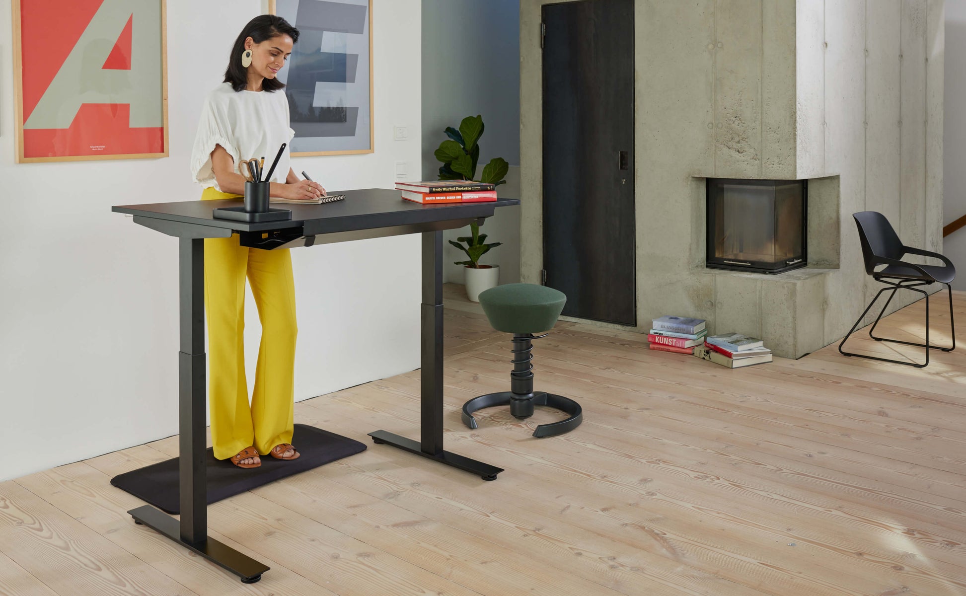Woman is standing on anti-fatigue mat Aeris Muvmat while working in a standing position at her desk 