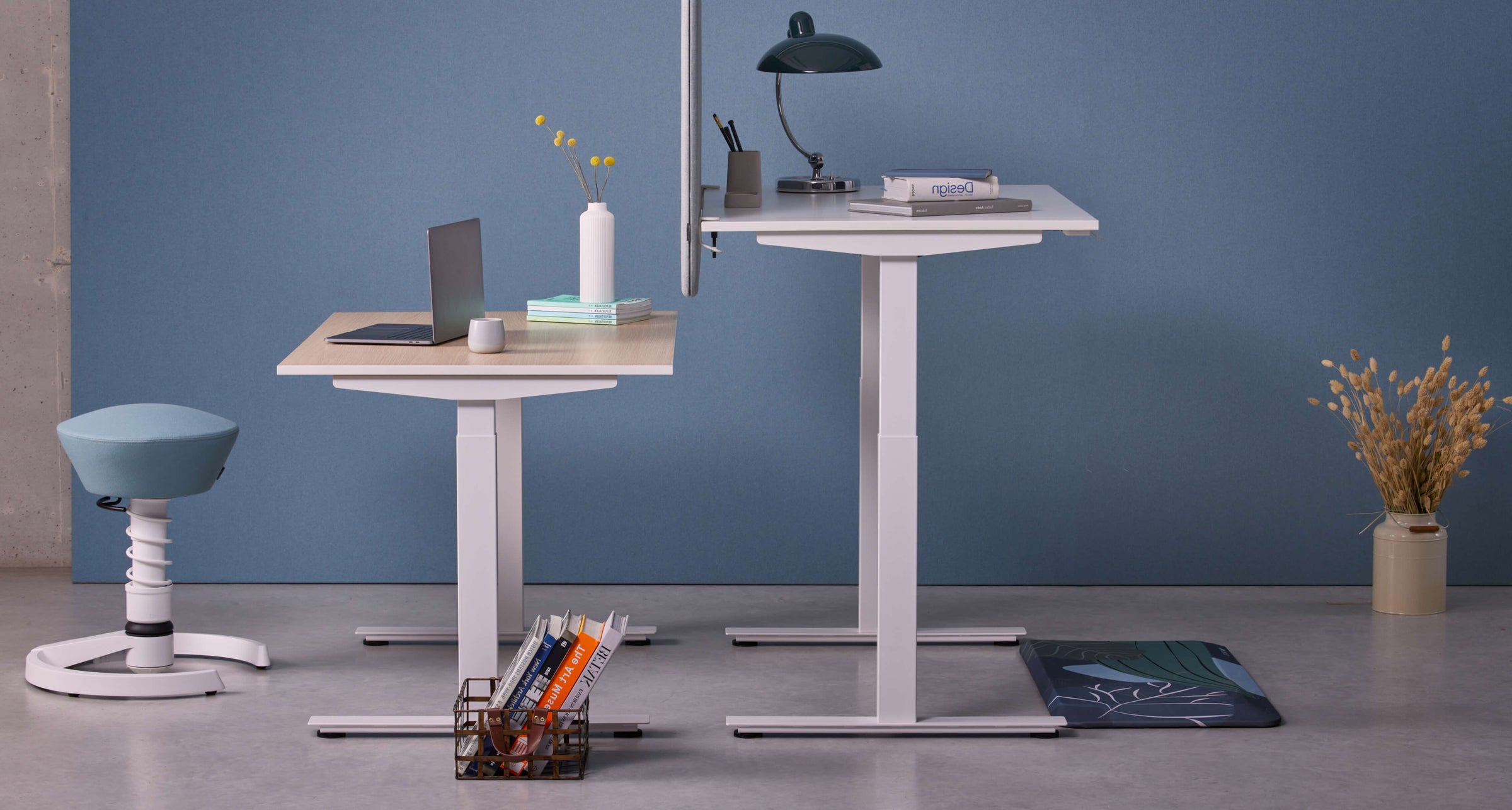 A desk with the Aeris Swopper in front of it and a standing workstation with the Aeris Muvmat in front of it.